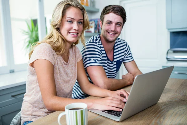 Sonriente pareja escribiendo en el ordenador portátil — Foto de Stock