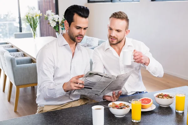 Homosexuální pár čtení noviny — Stock fotografie