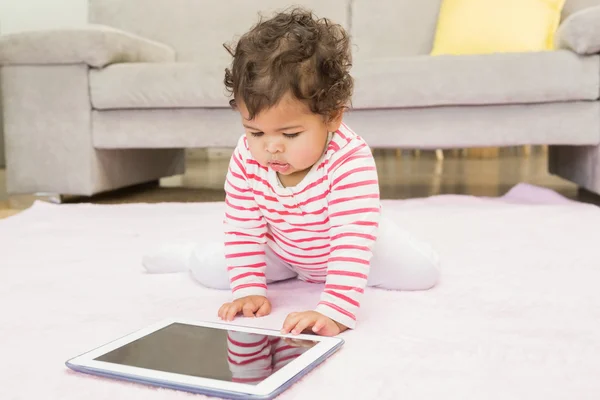 Baby on carpet with tablet — Stockfoto