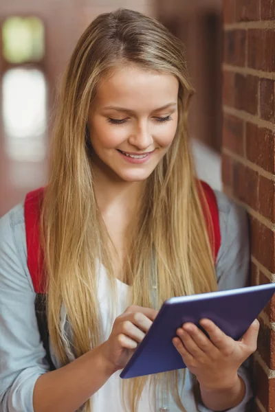 Lachende student met behulp van Tablet PC in de gang — Stockfoto