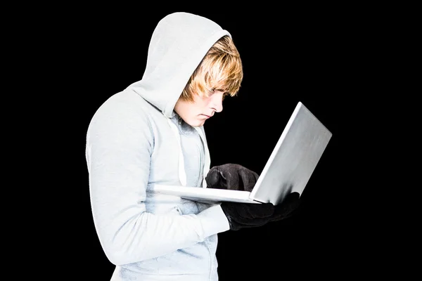 Koncentruje się człowiek z kapturem pisania na laptopa — Zdjęcie stockowe