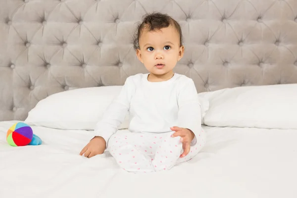 Bebê bonito sentado na cama — Fotografia de Stock