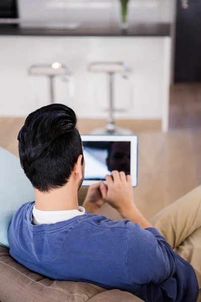 Man using tablet on couch — Stock Photo, Image