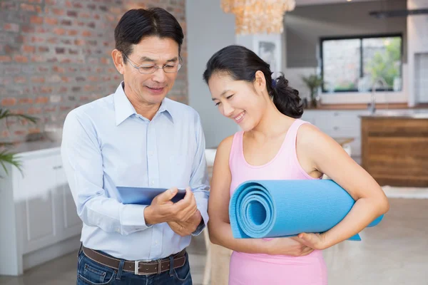 Couple using tablet and holding mat — Stock Fotó