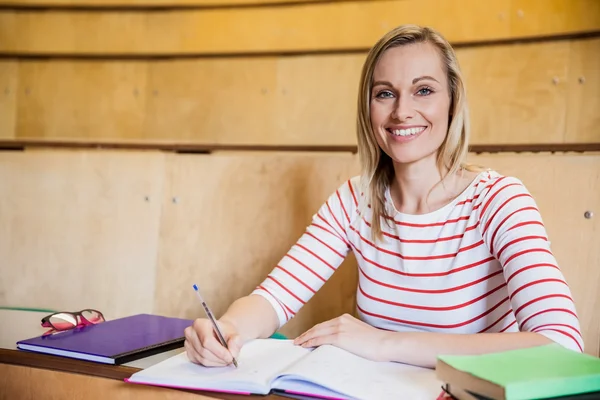 Happy kvinnlig student skriver anteckningar — Stockfoto