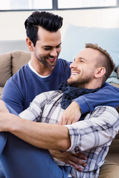 Gay casal abraçando no sofá — Fotografia de Stock