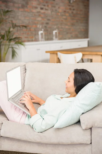 Brunetka uśmiechający się za pomocą laptopa — Zdjęcie stockowe