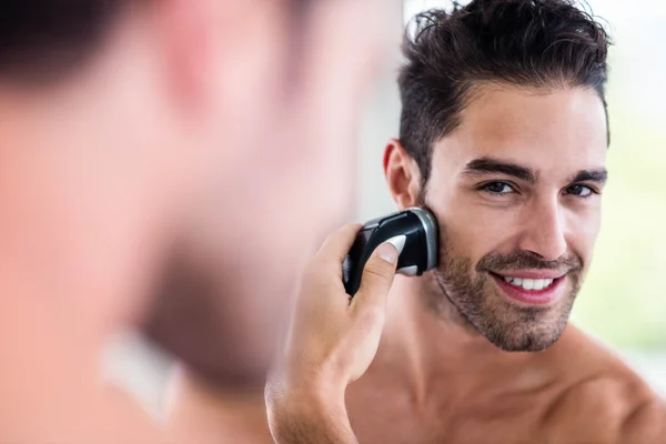 Handsome man shaving in mirror — Stock Photo, Image