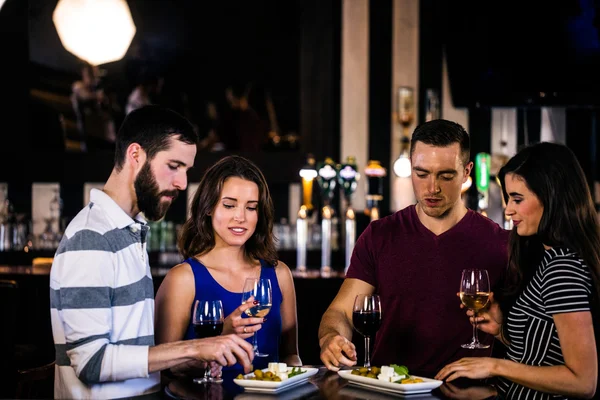 Amigos tendo um aperitivo com vinho — Fotografia de Stock