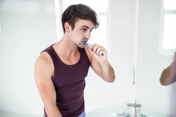 Knappe man van de reiniging van de tanden — Stockfoto