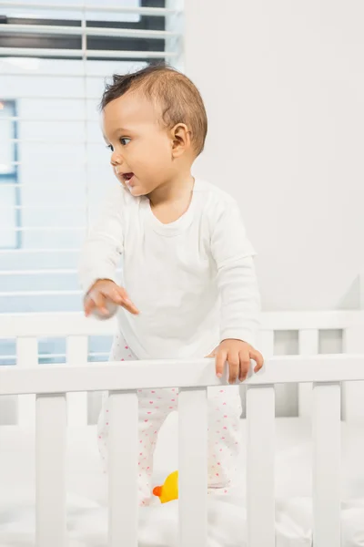 Cute baby standing in the crib — Stock Photo, Image