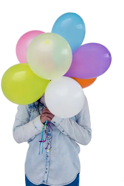 Mulher escondendo rosto atrás de balões coloridos — Fotografia de Stock