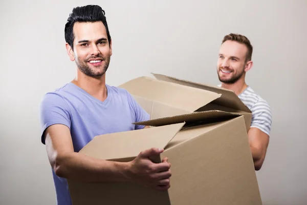 Gay couple holding boxes — Stock Photo, Image