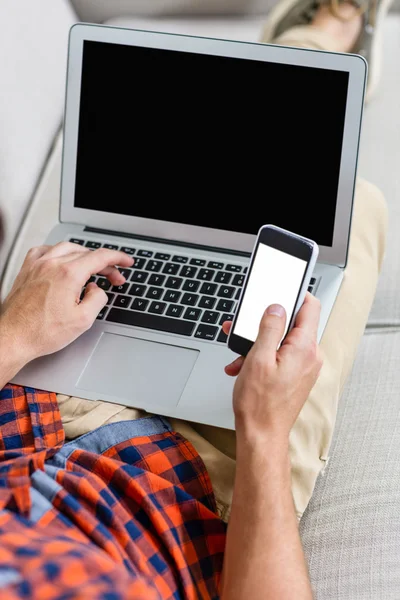 Mann benutzt Laptop und Smartphone — Stockfoto