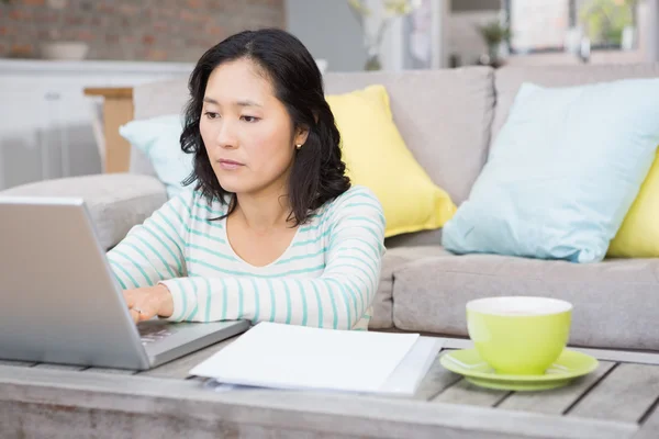 Poważna brunetka za pomocą laptopa — Zdjęcie stockowe