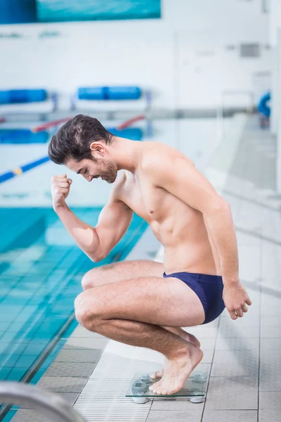 Hombre en forma triunfando en la escala de ponderación —  Fotos de Stock