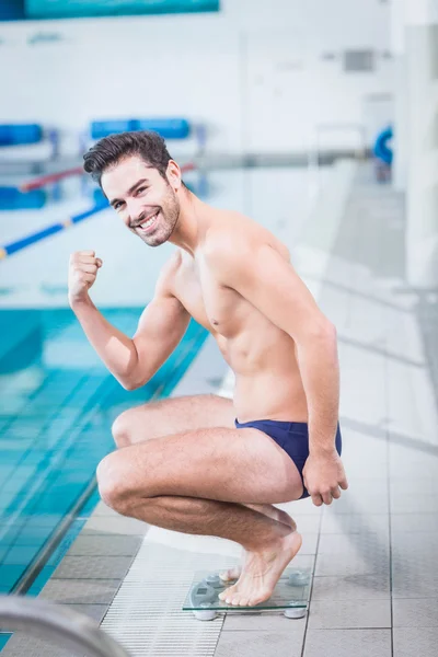 Fit mens triomfen op de schaal van de weging — Stockfoto