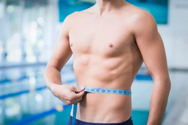 Hombre guapo midiendo su cintura — Foto de Stock