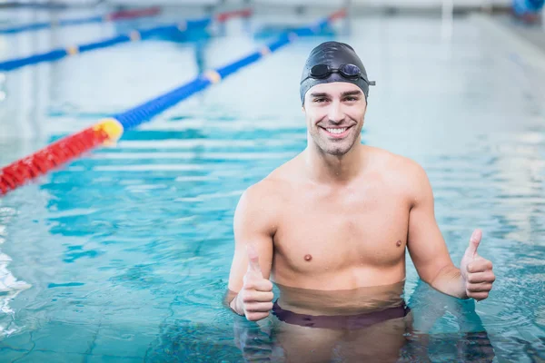 Stilig man med tummen upp i vattnet — Stockfoto