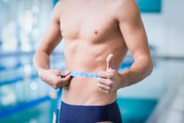 Hombre guapo midiendo su cintura — Foto de Stock