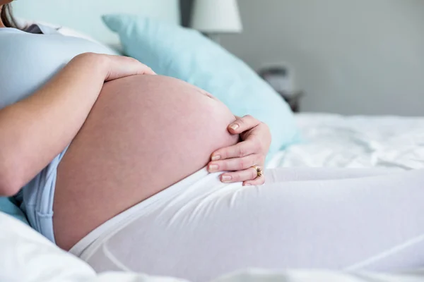 Mulher grávida sentada na cama — Fotografia de Stock