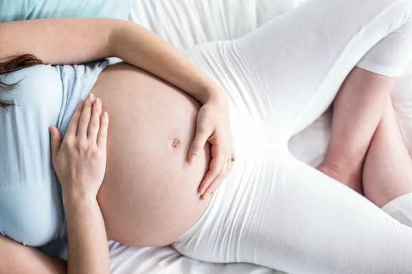 Donna incinta sdraiata sul letto — Foto Stock