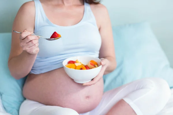 Mulher grávida comendo frutas — Fotografia de Stock