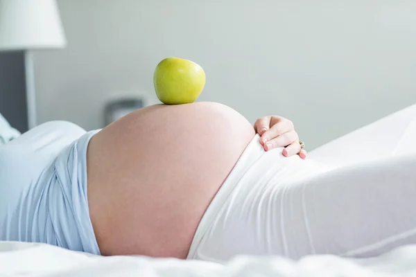 Terhes nő hasa almával — Stock Fotó