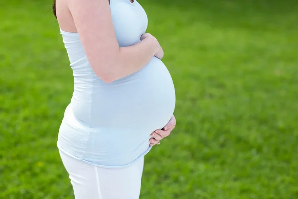 Schwangere berührt ihren Bauch — Stockfoto