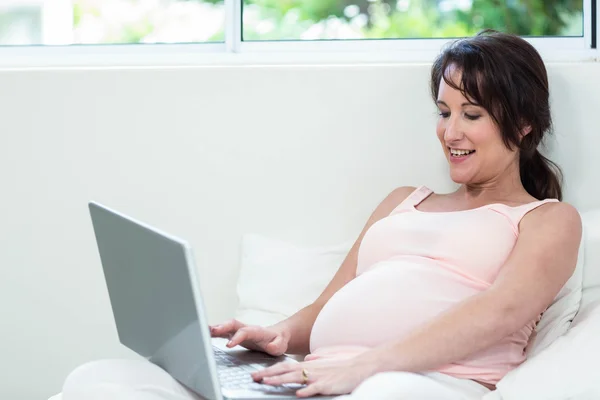 孕妇放松与她的笔记本电脑 — 图库照片