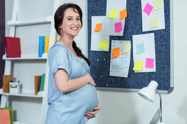 Χαμογελώντας έγκυος γυναίκα αγγίζει την κοιλιά — Φωτογραφία Αρχείου