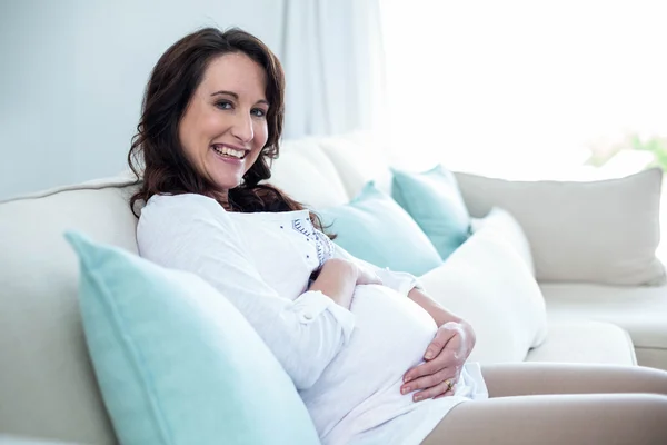 Kobieta w ciąży siedząc w salonie — Zdjęcie stockowe