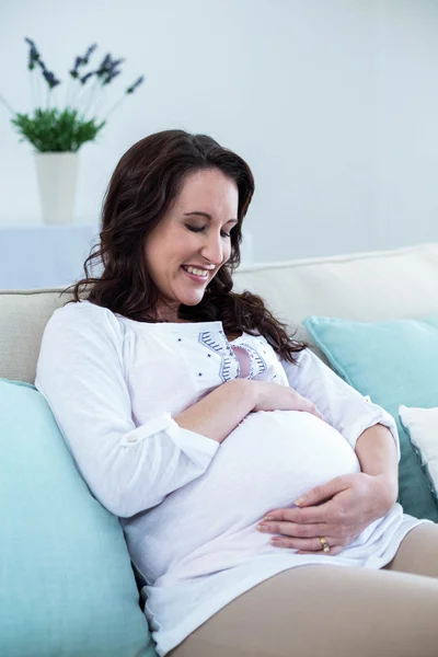 Mulher grávida sentada na sala de estar — Fotografia de Stock