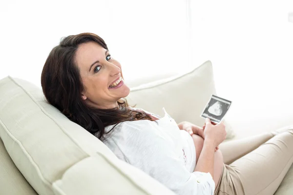 Mujer embarazada mirando ecografías — Foto de Stock
