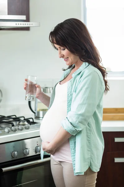 Mujer embarazada sosteniendo un vaso de agua — Foto de Stock