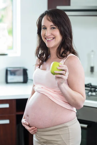Těhotná žena hospodářství jablko — Stock fotografie