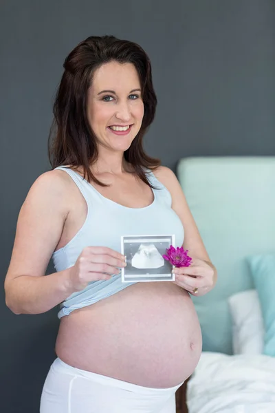 Mujer embarazada mostrando una imagen de ultrasonido — Foto de Stock