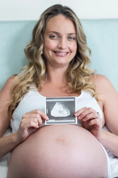 Donna incinta che mostra un'immagine ad ultrasuoni — Foto Stock