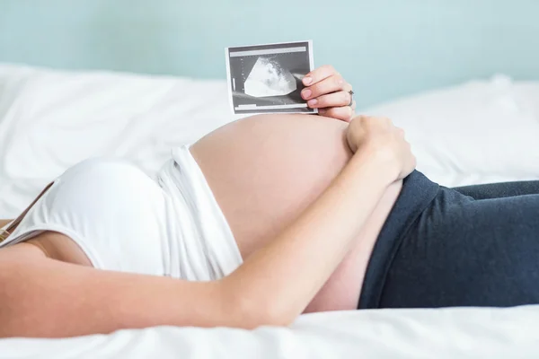 Donna incinta che mostra un'immagine ad ultrasuoni — Foto Stock