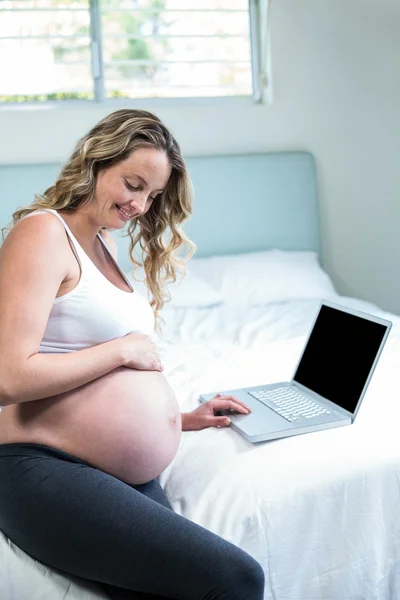 Mulher grávida usando um laptop — Fotografia de Stock