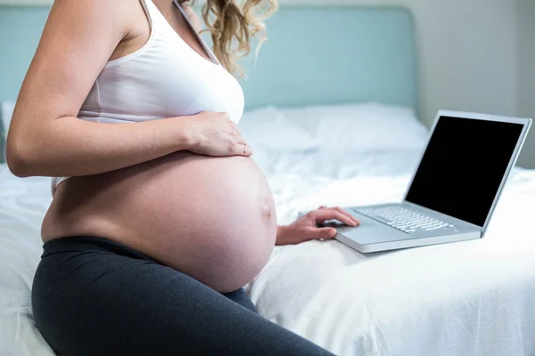 Mulher grávida usando um laptop — Fotografia de Stock