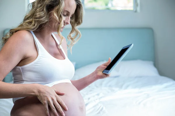 Kobieta w ciąży przy użyciu komputera typu tablet — Zdjęcie stockowe