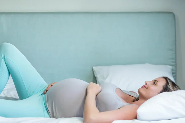 Gravid kvinna liggande på hennes säng — Stockfoto