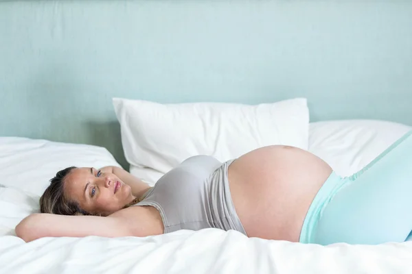 Zwangere vrouw liggend op haar parel — Stockfoto