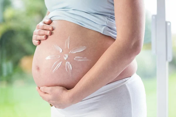 Gravid kvinna med grädde på magen — Stockfoto