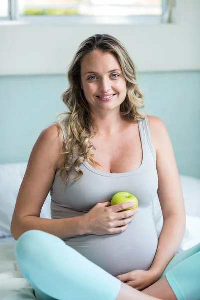 Mujer embarazada sosteniendo una manzana — Foto de Stock