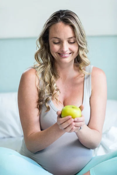 Mujer embarazada sosteniendo una manzana — Foto de Stock