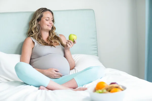 Schwangere hält einen Apfel in der Hand — Stockfoto