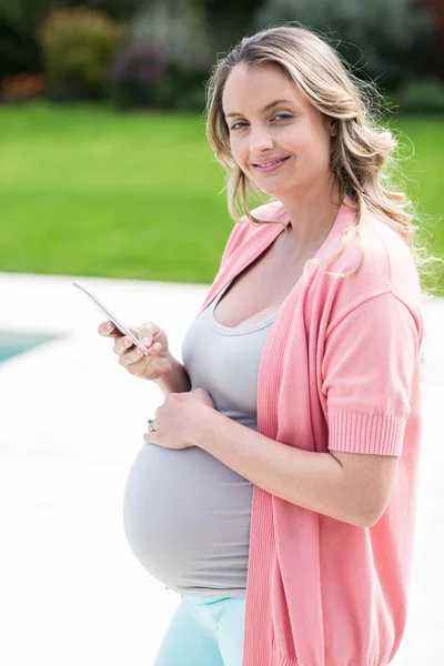 Mulher grávida tocando sua barriga e mensagens de texto — Fotografia de Stock