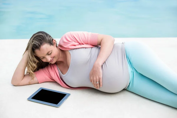 Femme enceinte se détendre à l'extérieur en utilisant un comprimé — Photo